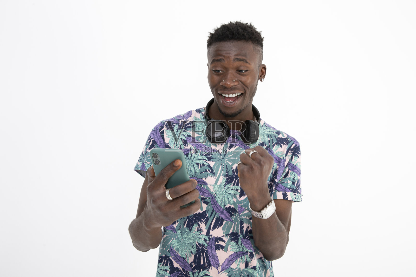 年轻的非洲裔黑人男子穿着有图案的彩色t恤，戴着耳机，做出不同的面部表情。照片摄影图片