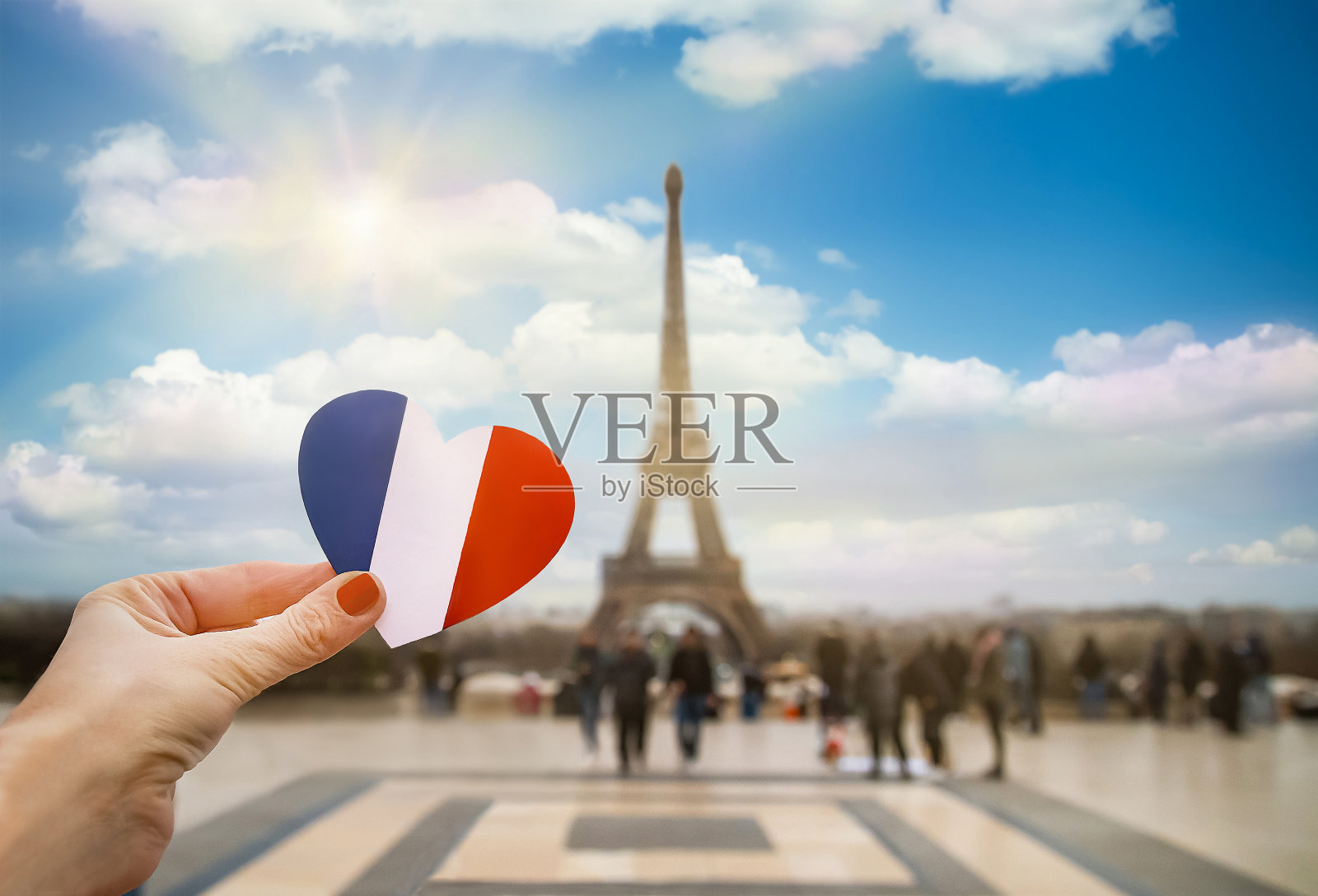 女孩的手握着法国国旗颜色的心。照片摄影图片