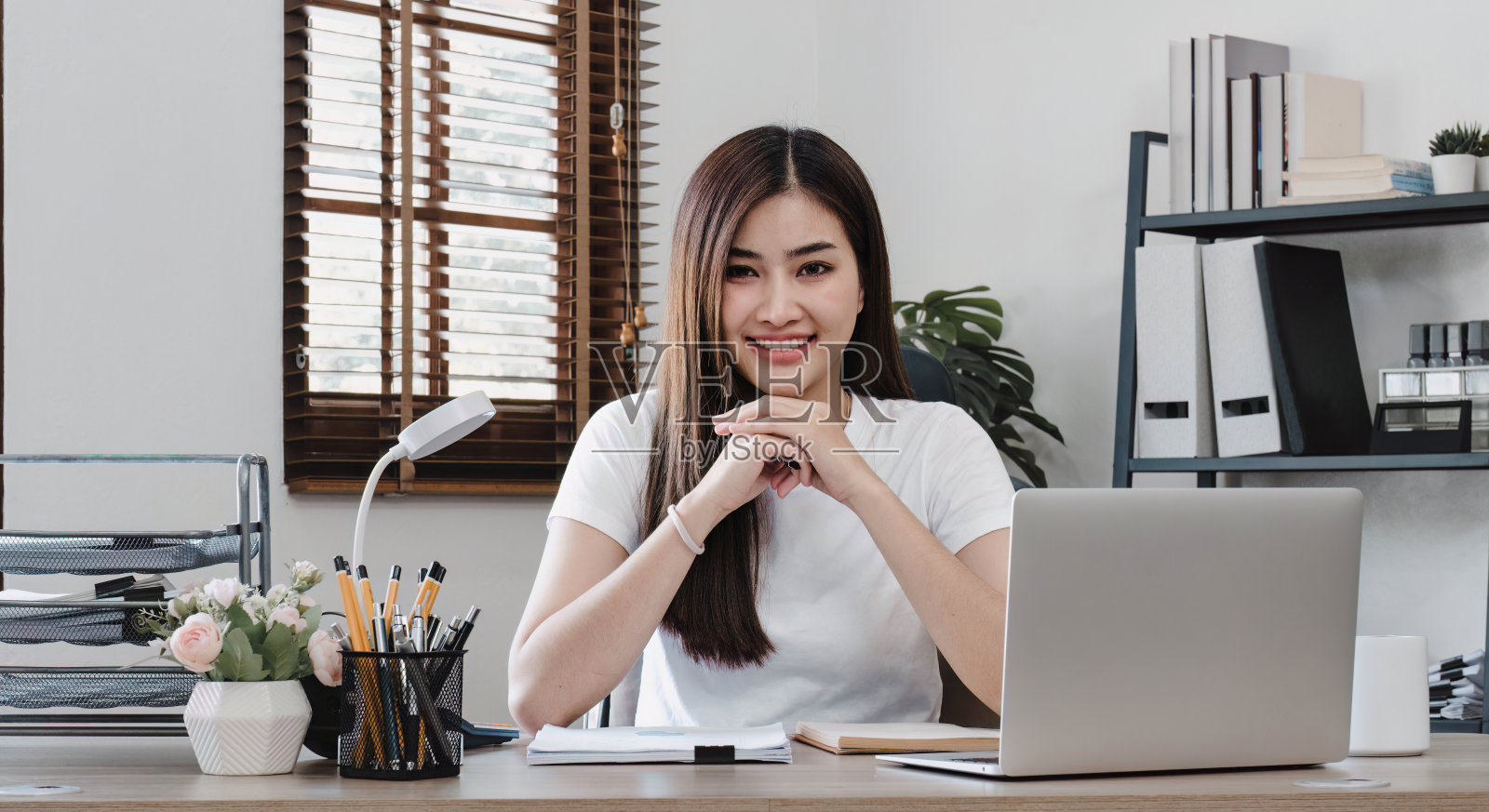 商业女性使用计算器在办公室的木桌上做数学金融和商业工作背景，税务，会计，统计和分析研究概念。照片摄影图片