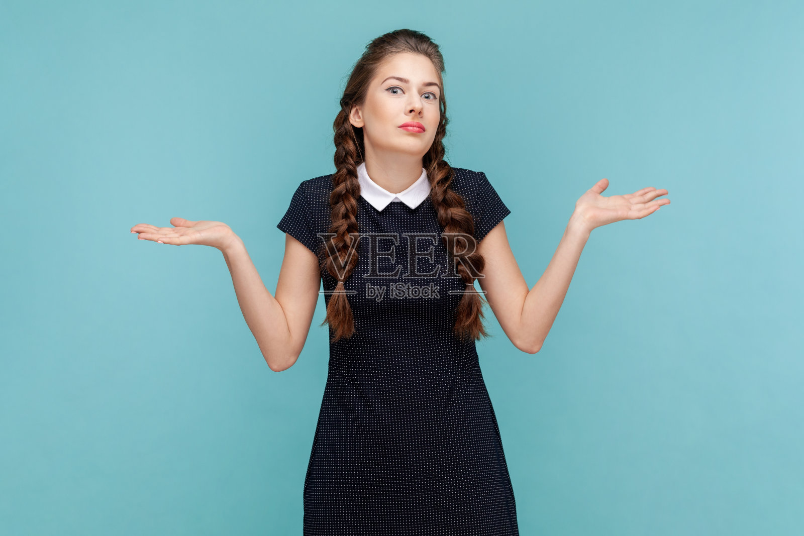 疑惑不定的女子摊开双手，耸着肩膀，不知如何做决定。照片摄影图片