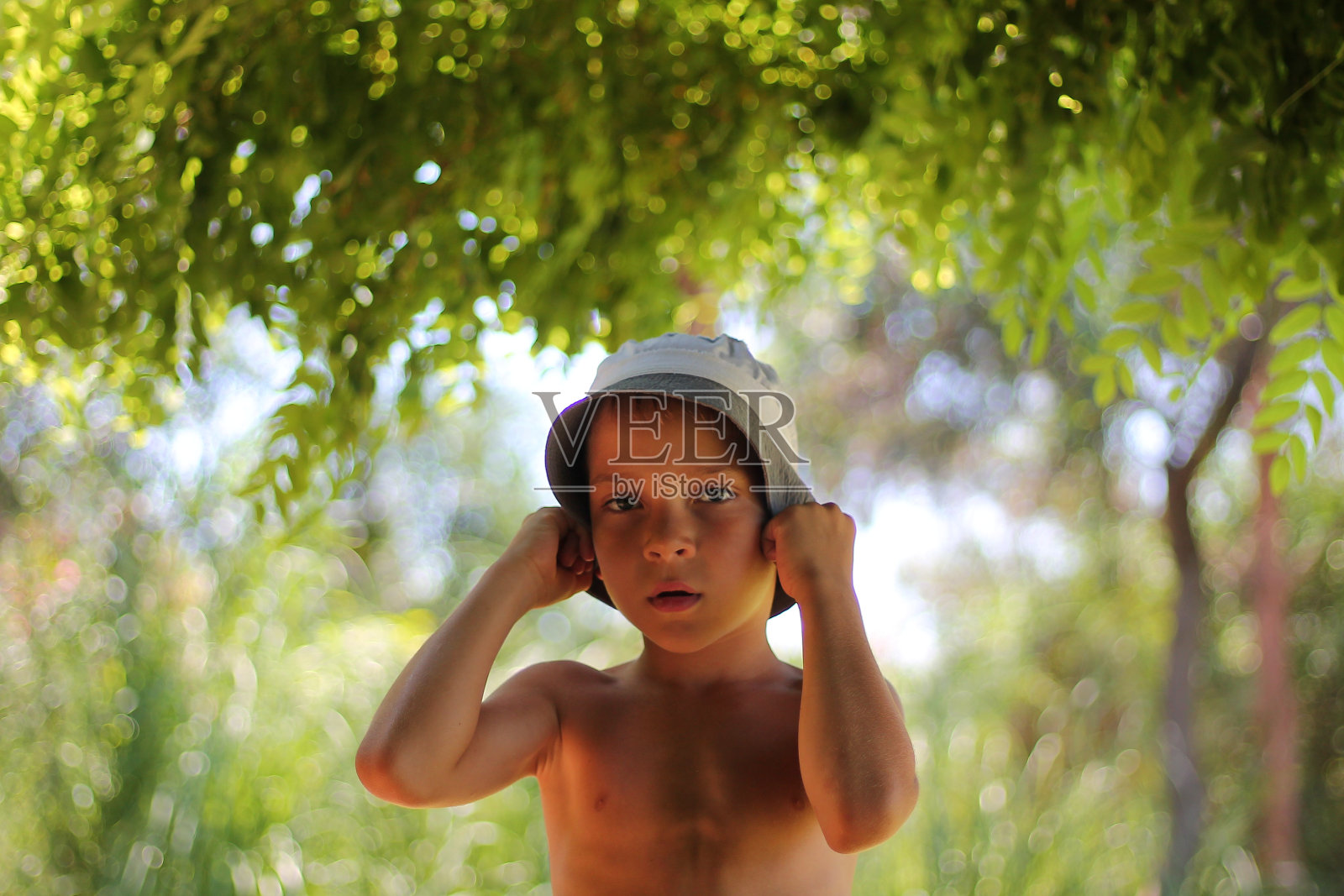 一个英俊的学生肖像在树叶在夏天。暑假在生态洁净区。生态旅游和环保理念。照片摄影图片
