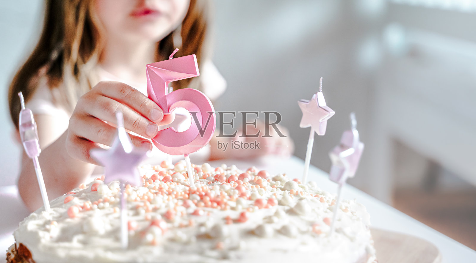 自制蛋糕上的大粉色5号蜡烛。创造性地祝贺小女孩五周年。5岁生日的节日装饰，浇头，化妆。节日快乐，和妈妈，家人聚会照片摄影图片