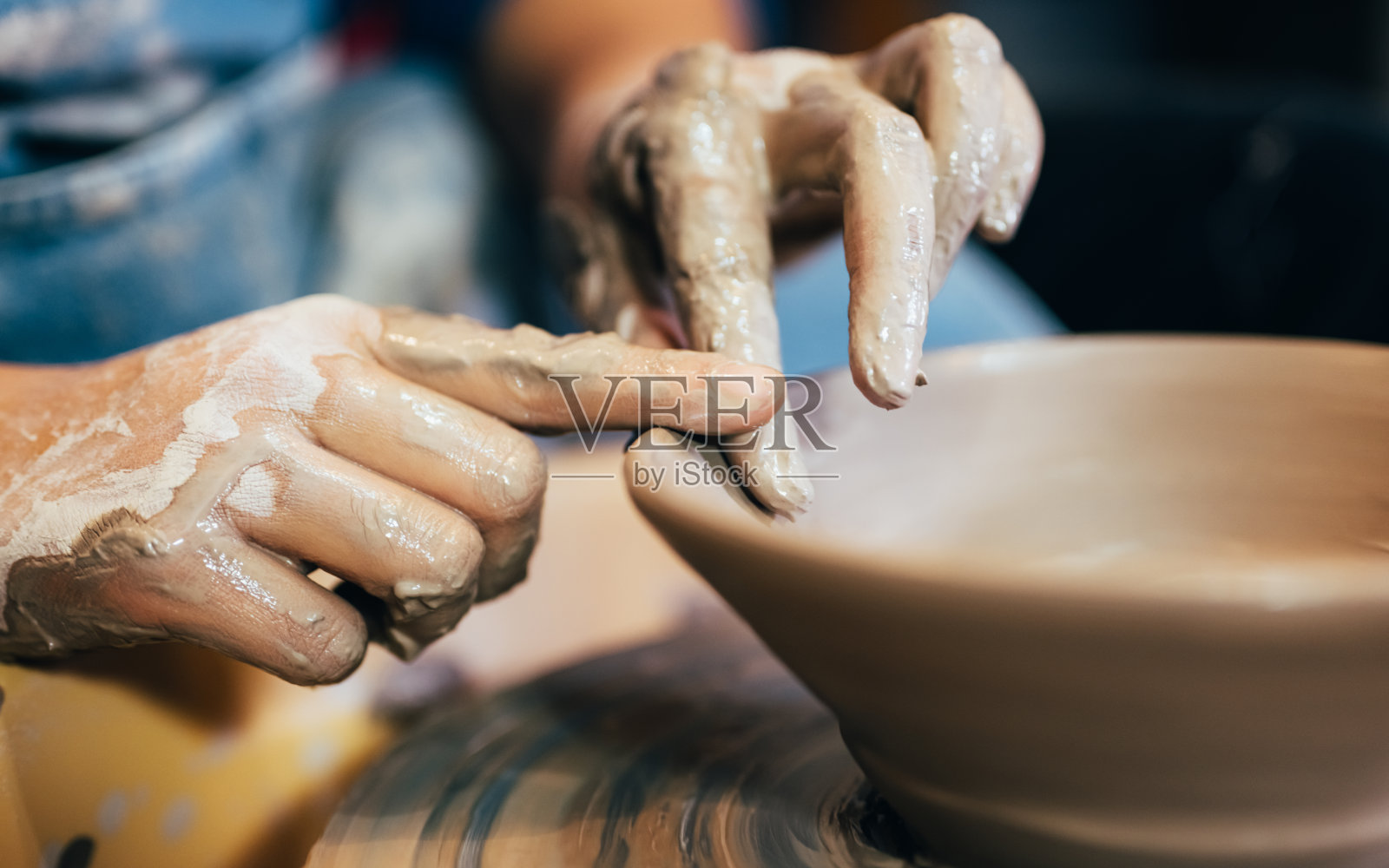 陶工工匠在车间的陶工轮圈上制作陶土壶照片摄影图片