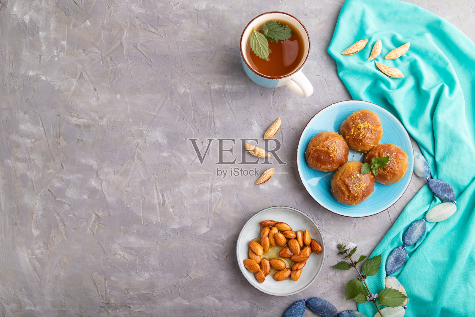 传统的土耳其甜点sekerpare杏仁和蜂蜜在灰色混凝土，俯视图，复制空间。照片摄影图片