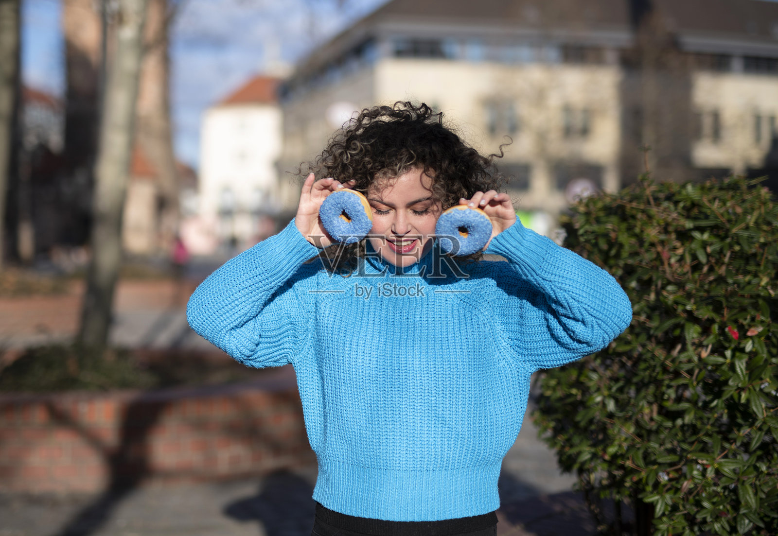 年轻时尚的女人在户外吃甜甜圈照片摄影图片