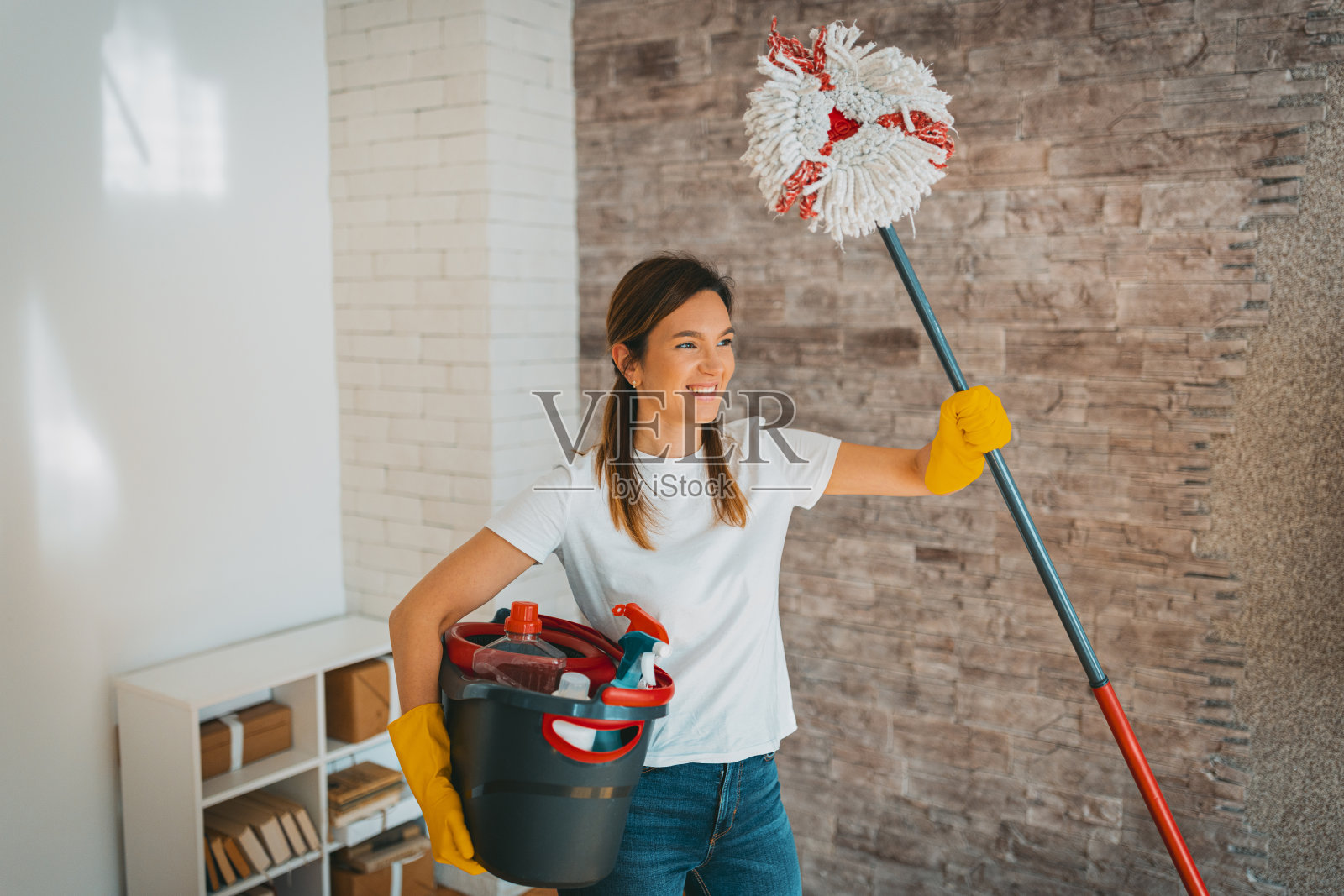 快乐的女人手里拿着拖把和水桶照片摄影图片