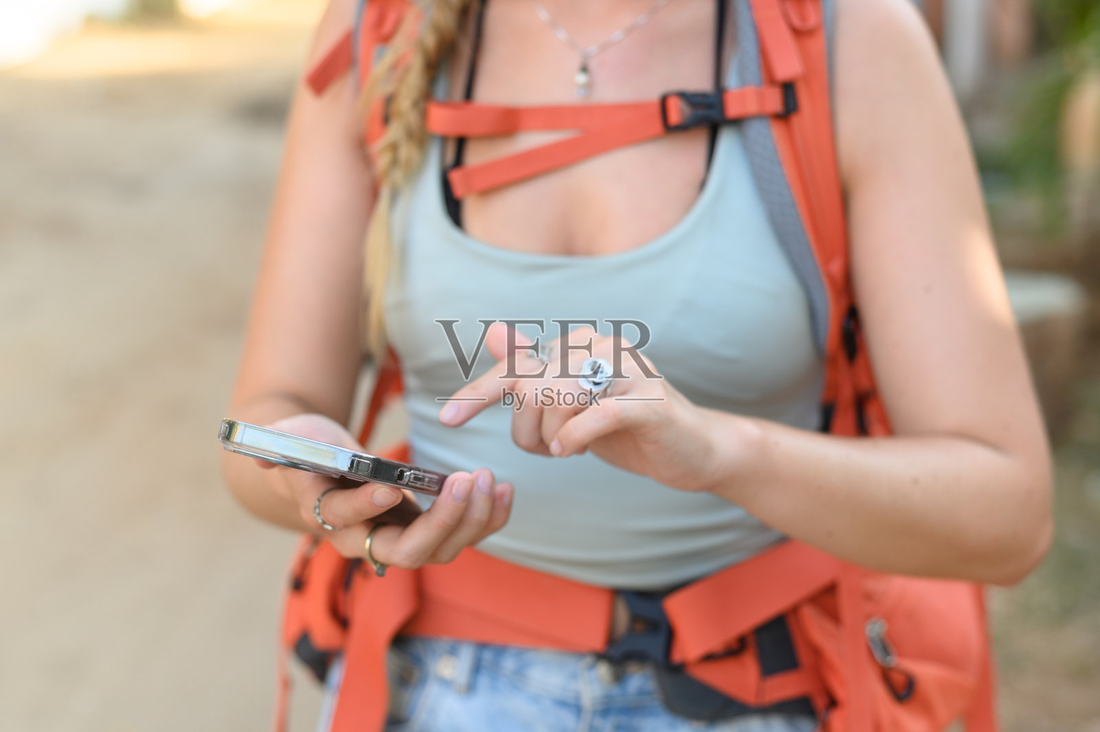 不认识的女旅行者拿着智能手机检查照片摄影图片