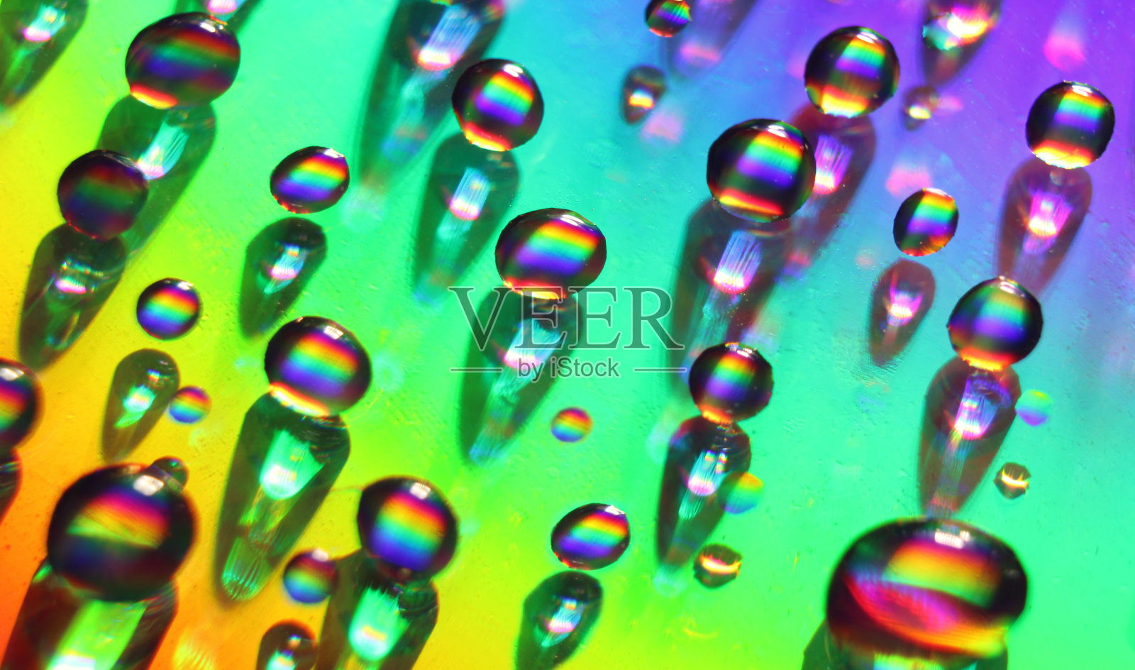 水滴在玻璃上。彩虹背景。彩虹在水滴里。特写摄影。微距摄影。照片摄影图片