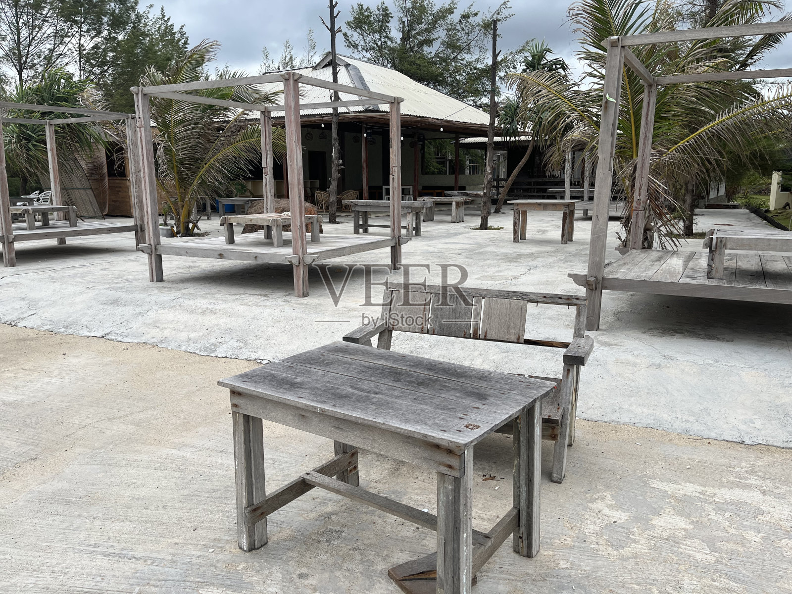 在海滩和桌子的上方，天空是一幅巨大的蓝色画布，点缀着蓬松的白云照片摄影图片