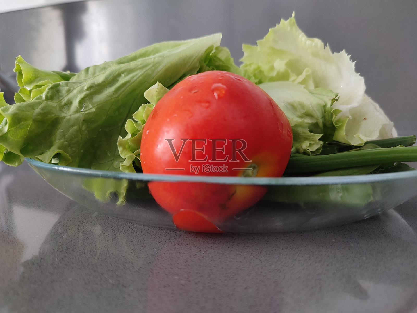 有机生菜和番茄放在盘子里。照片摄影图片