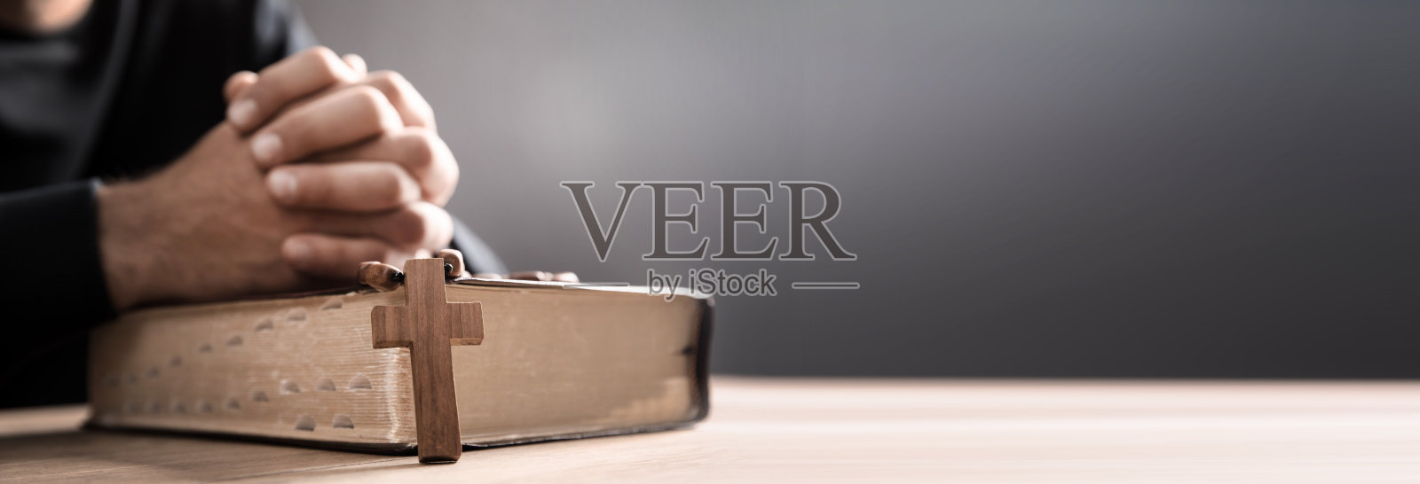 祈祷者拿着十字架和圣经照片摄影图片