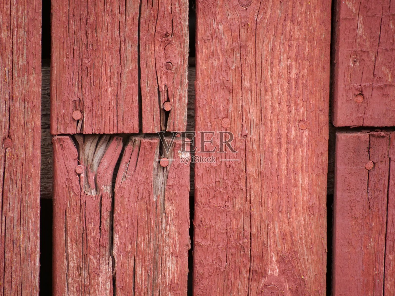 在白天，旧的土红色墙壁被涂上了红色的护根涂料照片摄影图片