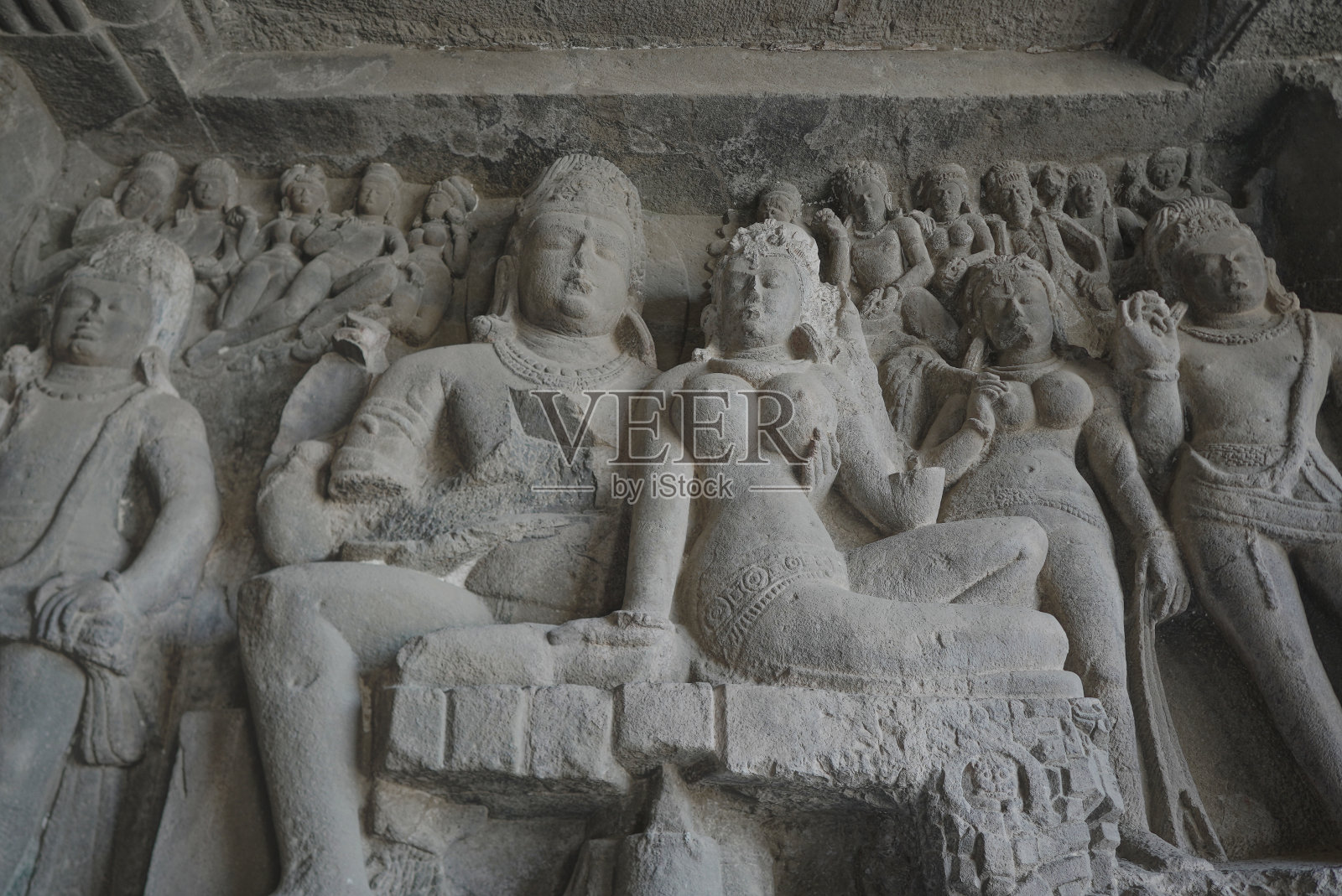 艾洛拉洞穴内部的一个橙色石雕的细节，描述了魔王拉文试图举起湿婆神和帕瓦蒂。照片摄影图片