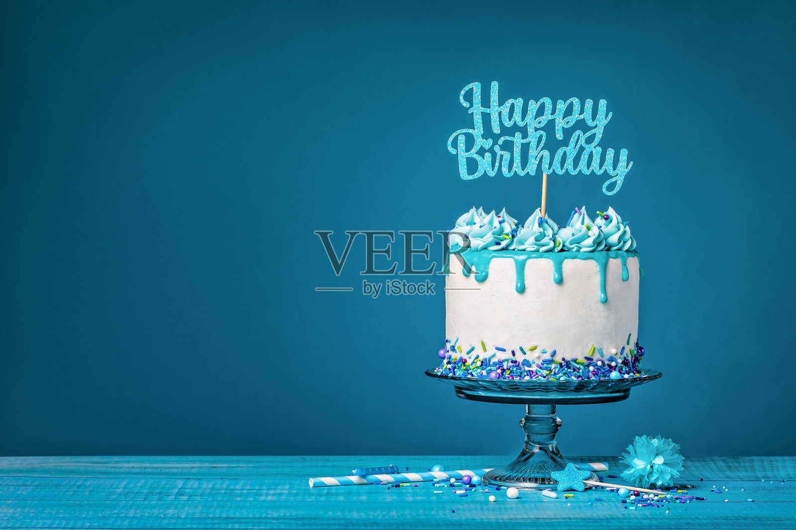 白色生日蛋糕，蓝绿色甘纳许，蓝色背景照片摄影图片