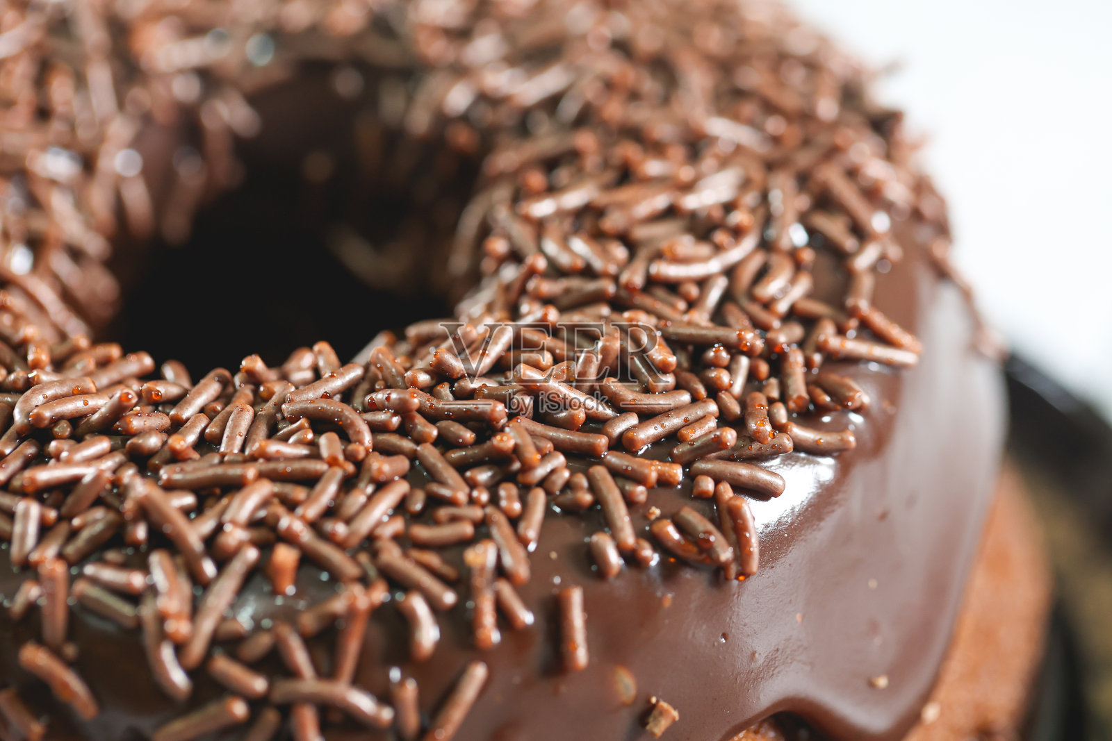 一种巧克力蛋糕，上面有巧克力糖霜和巧克力粉装饰。在巴西，它被称为bolo de brigadeiro。照片摄影图片