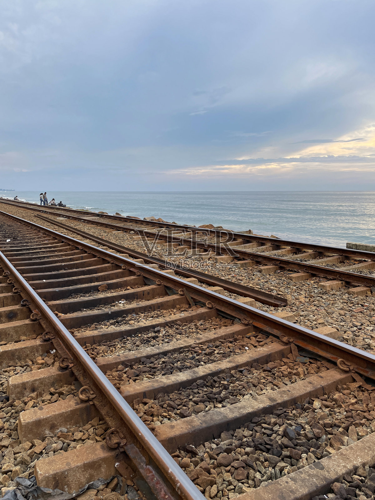 斯里兰卡科伦坡，与海岸线平行的空海岸线(南线)铁路线特写，金属铁轨和砾石，前景为焦点照片摄影图片