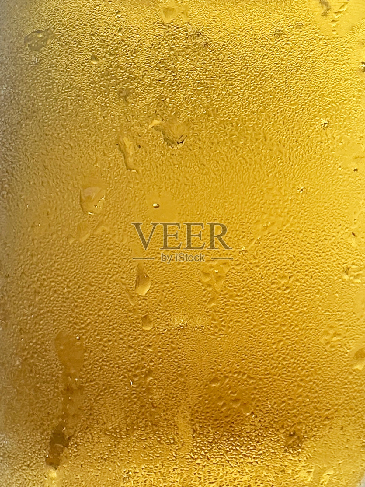 全帧图像的啤酒在玻璃酒杯覆盖凝结与气泡形成泡沫的泡沫头在啤酒的顶部，重点在前景照片摄影图片