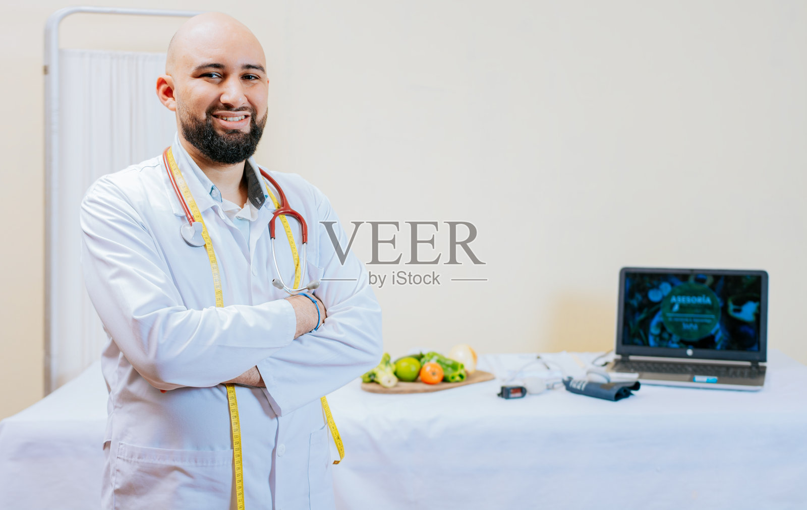 微笑的男性营养师在他的工作场所的肖像。在她的办公室里交叉双臂微笑的营养师医生。微笑的专业营养师肖像。照片摄影图片