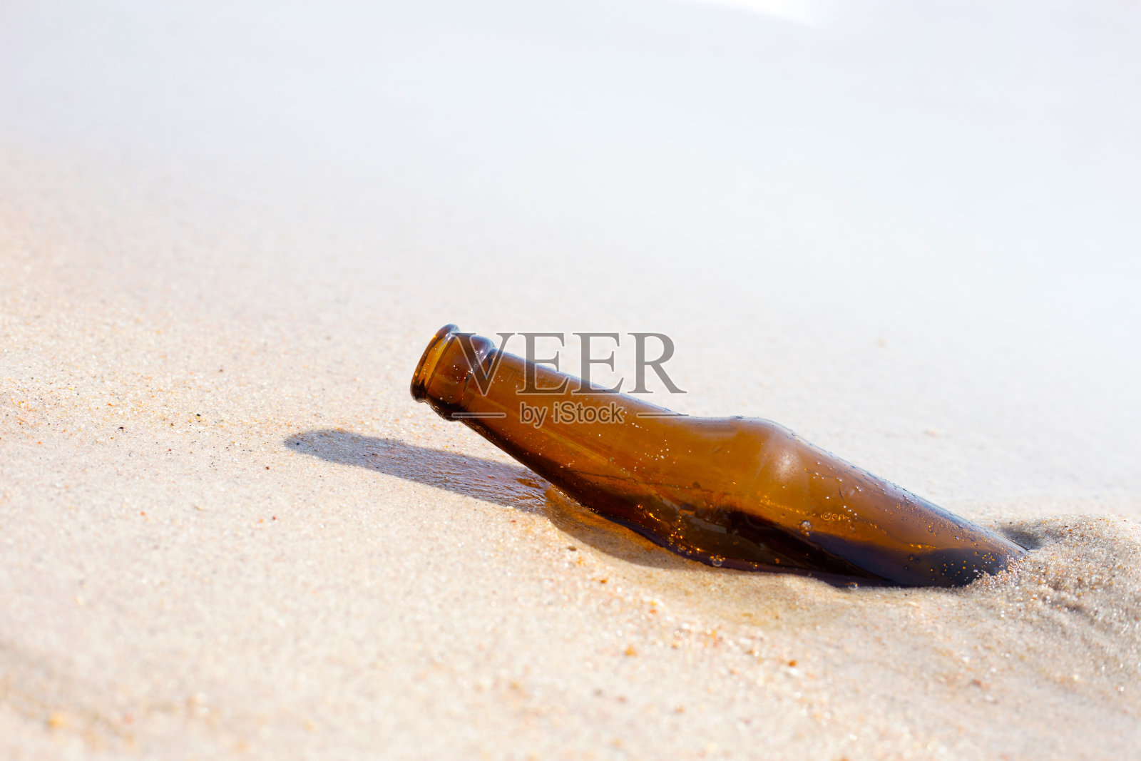 沙滩上的玻璃瓶照片摄影图片