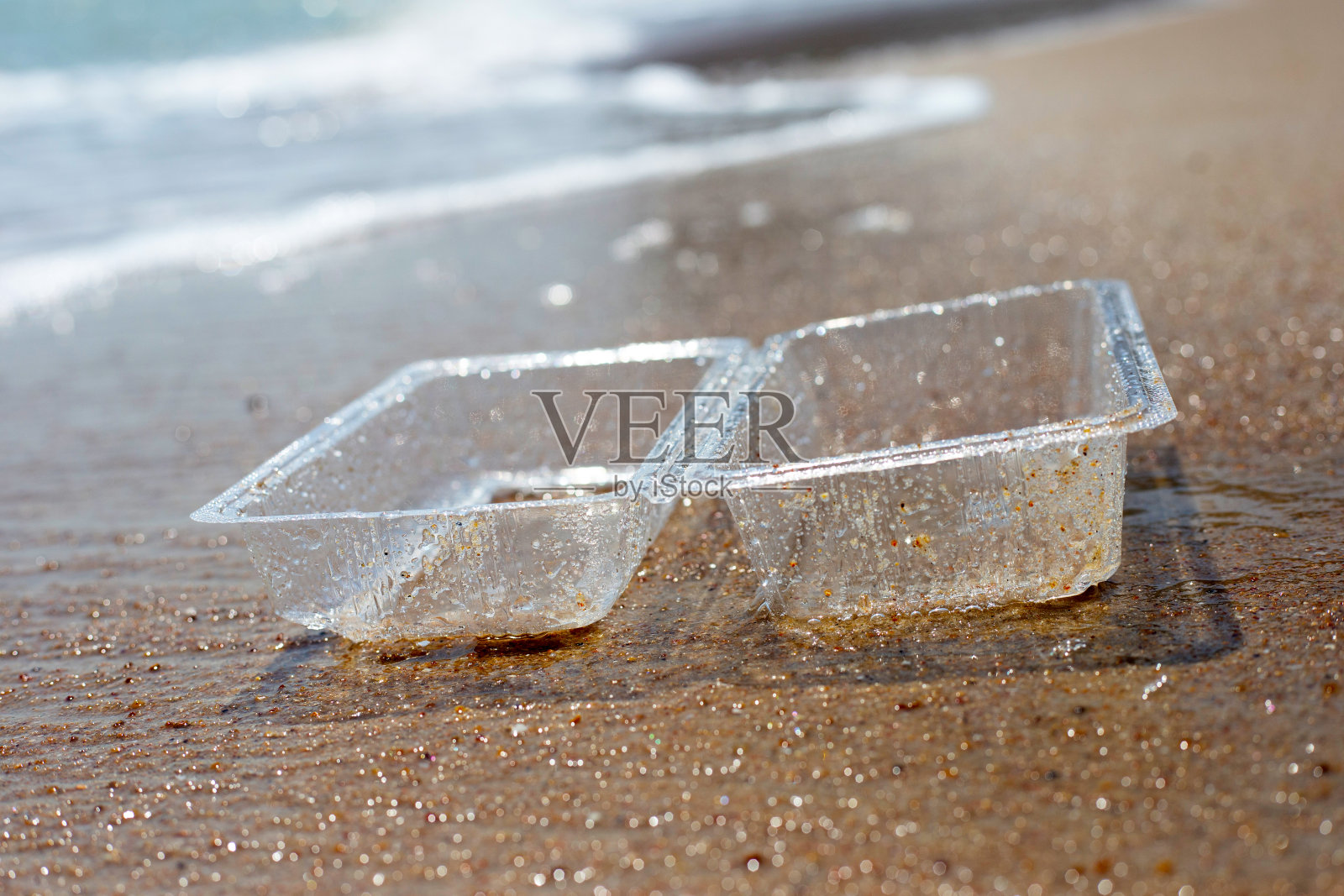 海滩上的塑料食物容器照片摄影图片