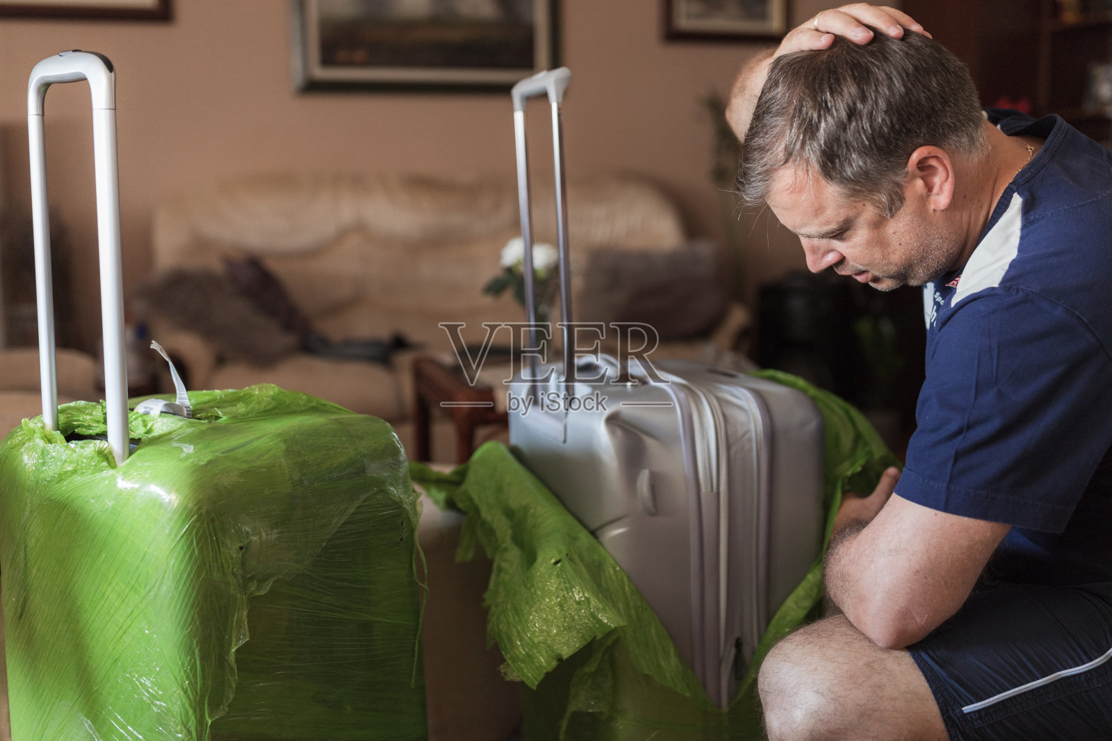 一名紧张的男子在机场检查破损的行李照片摄影图片