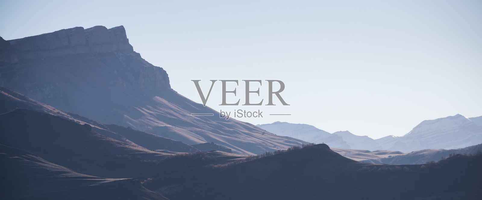 在一个阳光明媚的秋日早晨，极简主义，山脉的色调透视，远处山坡和山脊的山景全景照片摄影图片