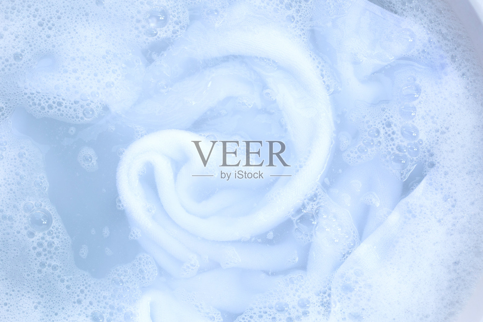 毛巾浸泡在洗衣粉水溶解的俯视图。衣服的概念照片摄影图片