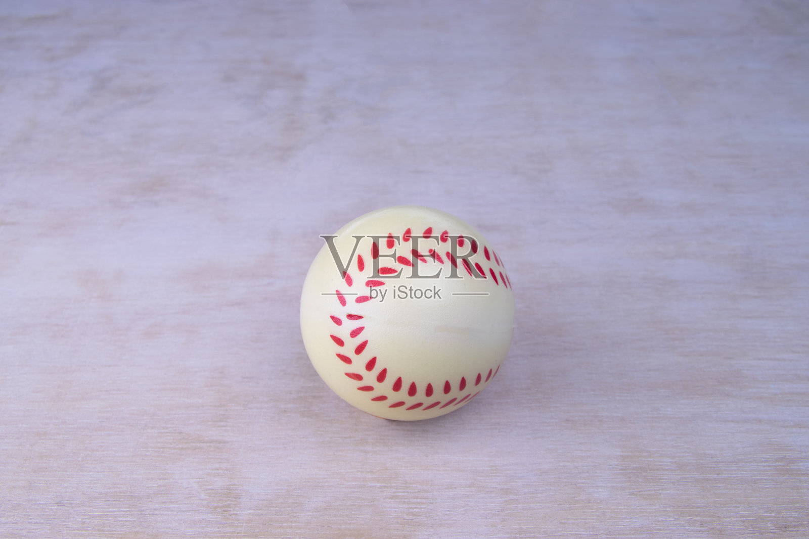 棒球是在白色的木纹上用橡胶缝成的照片摄影图片