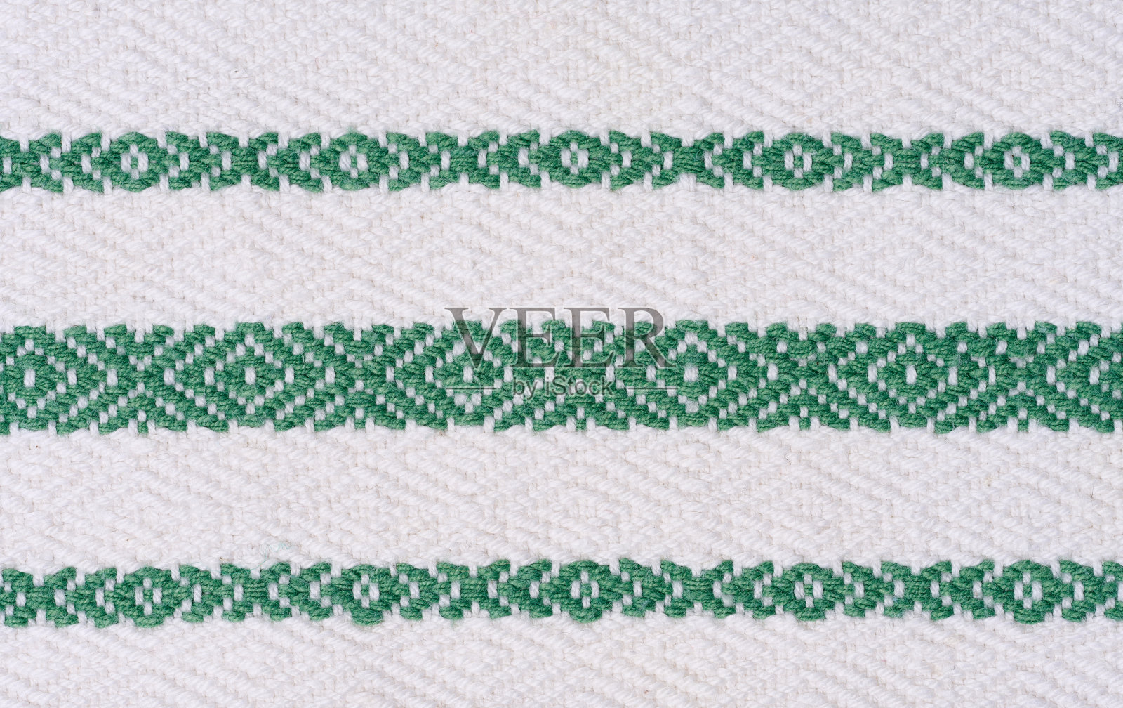 一块棉布，用于制作带有绿色刺绣元素的桌布和厨房毛巾照片摄影图片