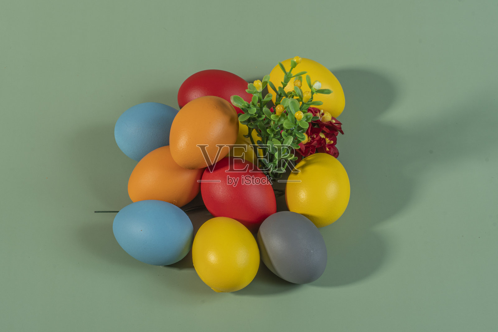 彩色的鸡蛋，象征着复活节，在五颜六色的背景和花朵上照片摄影图片