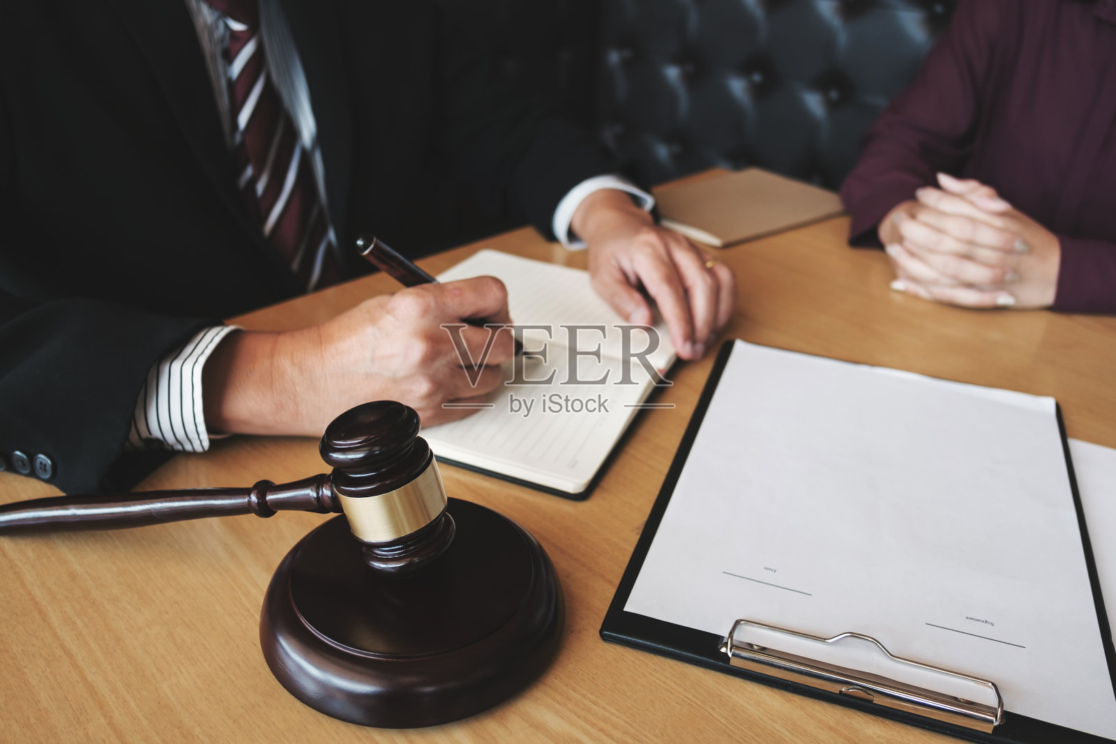 劳动法概念。律师在法官木槌下签署法律文件照片摄影图片