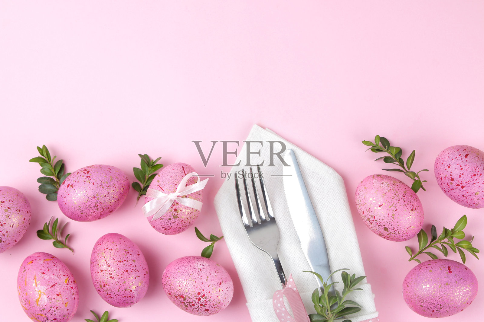 复活节。粉色的复活节彩蛋和盘子，刀叉在时尚的粉色背景上。复活节餐桌摆设。复活节快乐。假期。俯视图照片摄影图片