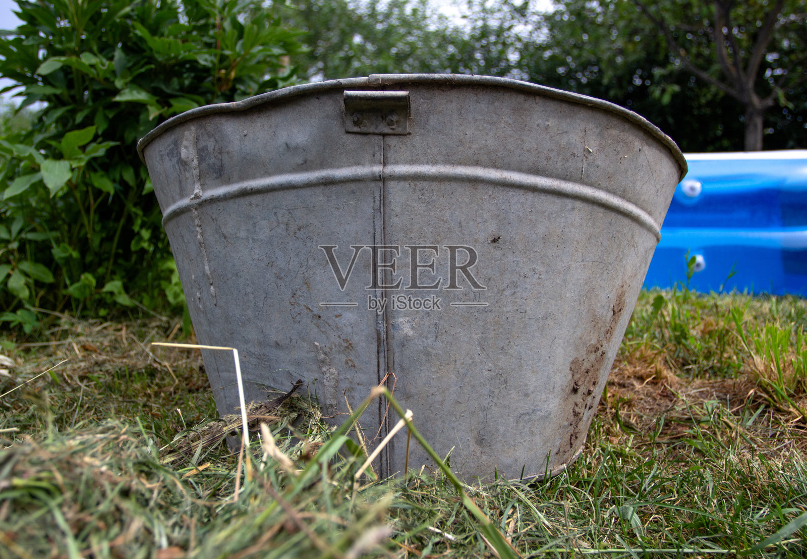 旧的金属盆子在草地上洗澡照片摄影图片