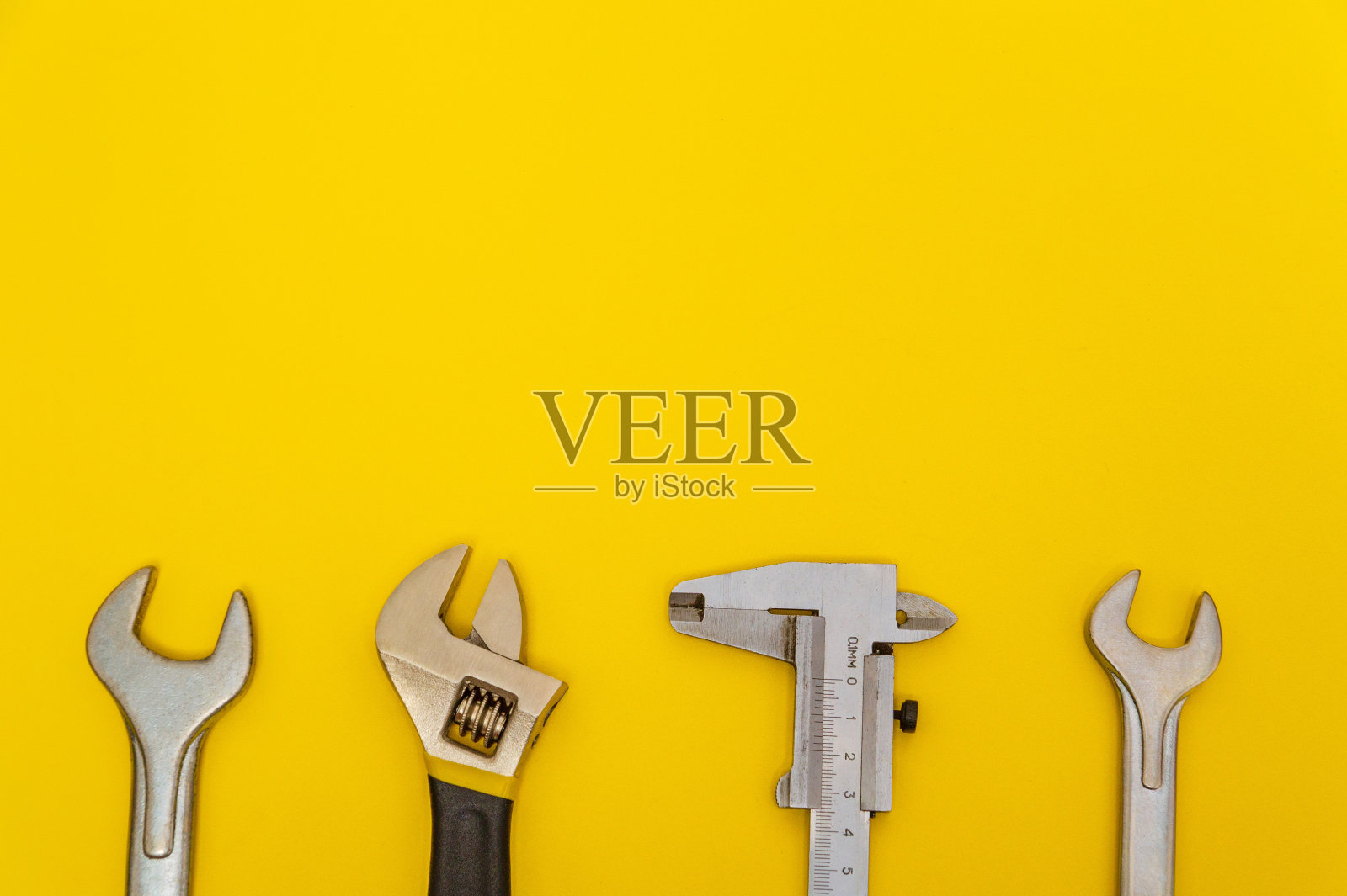 黄色背景的水管工必备工具照片摄影图片