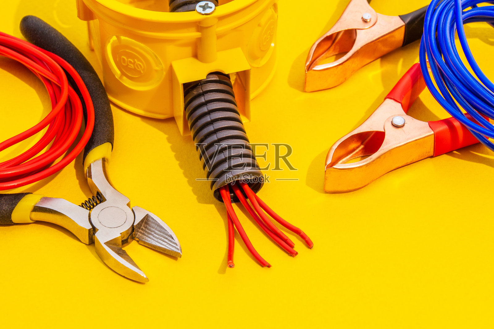 更换或修理电气设备的备件、工具和电线(黄色背景)照片摄影图片
