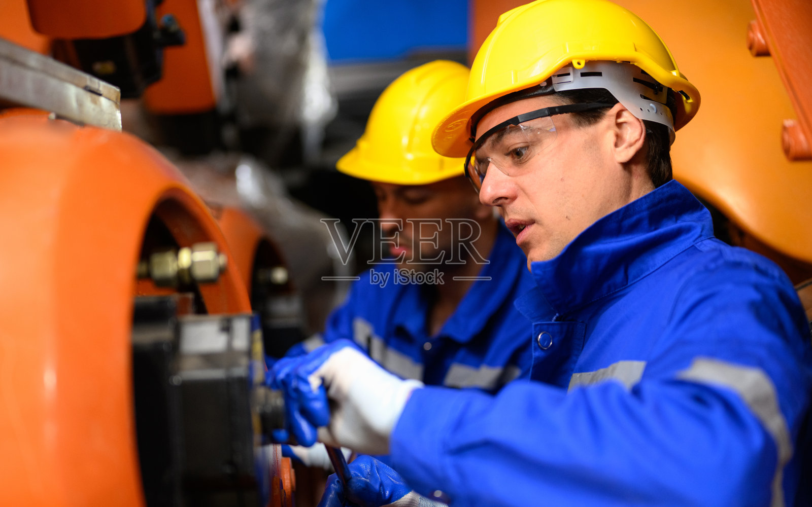 工业工厂机器机械臂的专业维修工人照片摄影图片