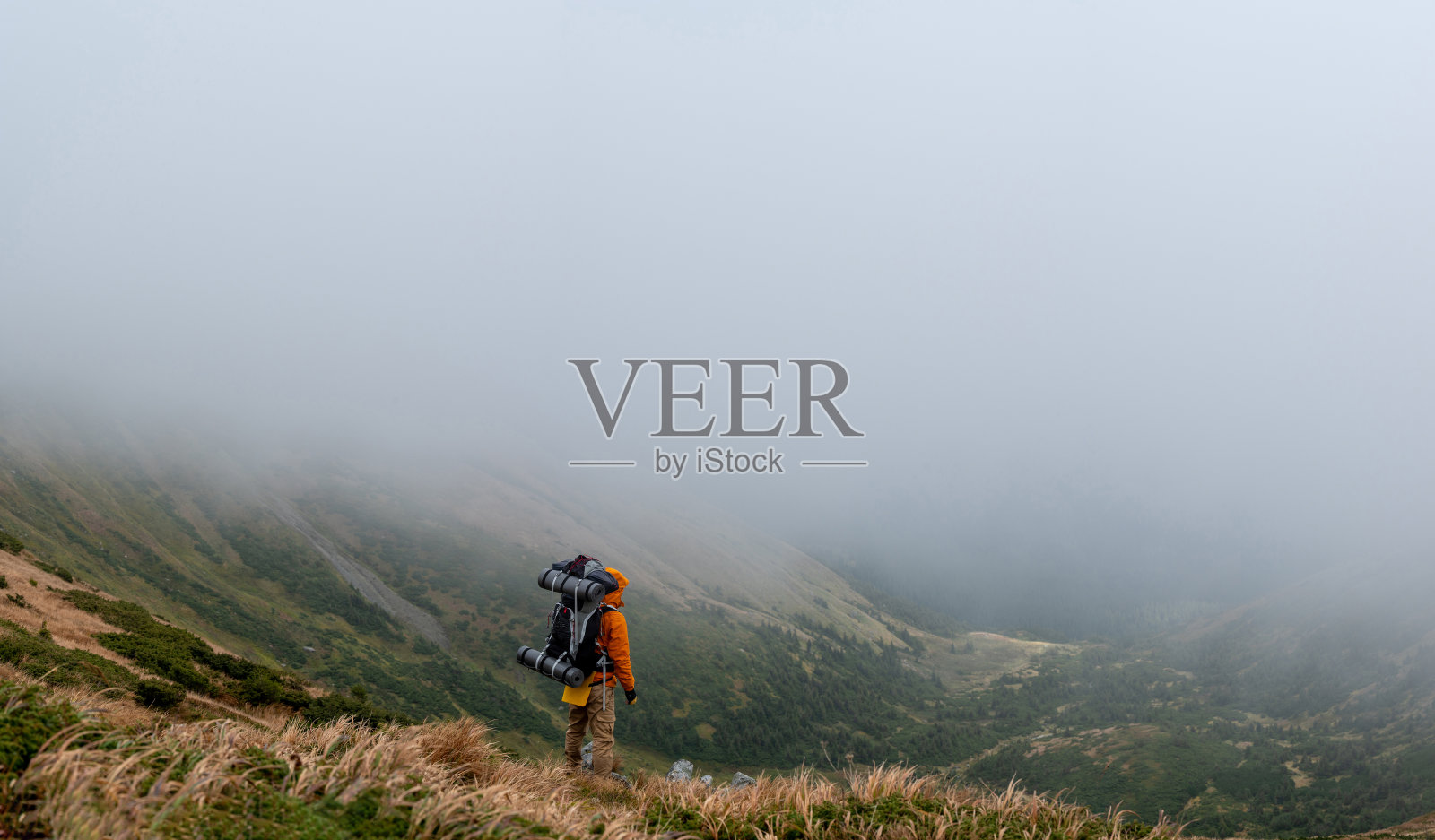 游客背着背包，背景是风景如画的喀尔巴阡山脉，秋色如画的喀尔巴阡山脉。照片摄影图片