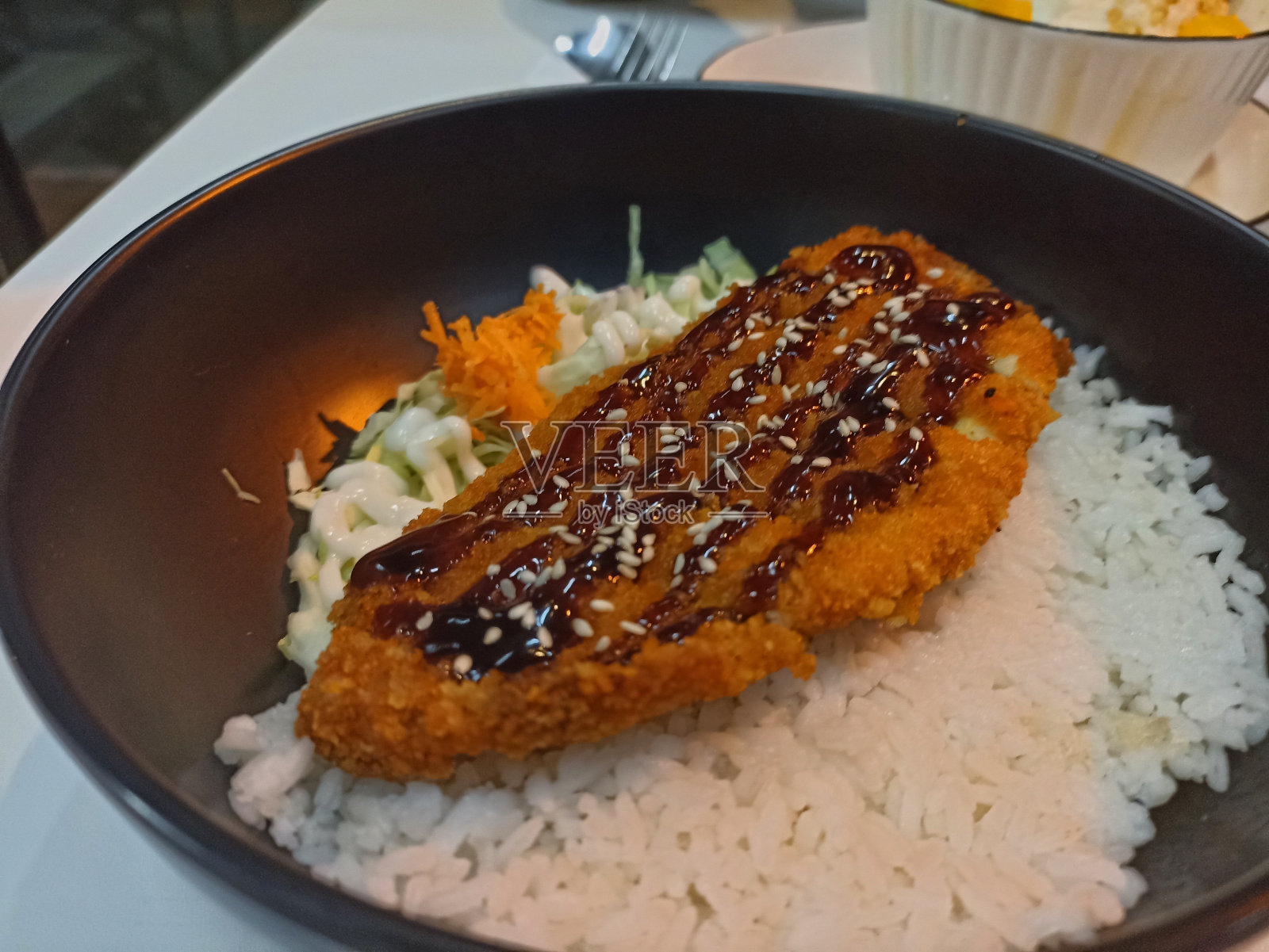 鸡排配米饭和沙拉，装在黑碗里照片摄影图片