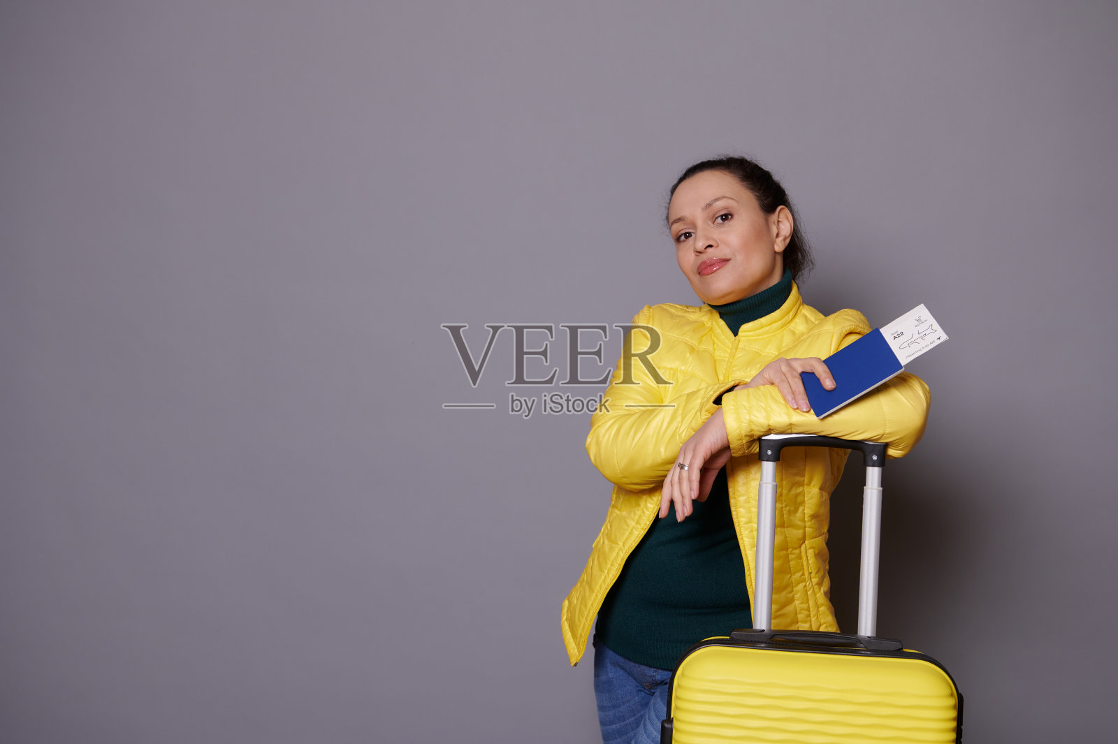 时尚女乘客出国旅行，去度假，等待登机，站在黄色行李箱旁照片摄影图片