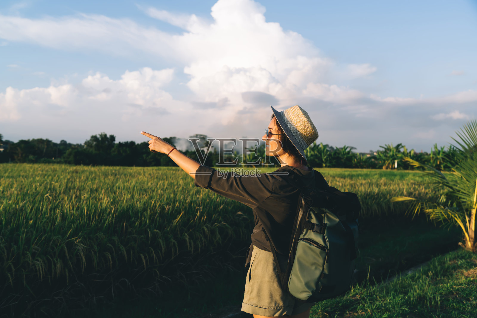 年轻的女性背包客正在欣赏绿色稻田的自然照片摄影图片