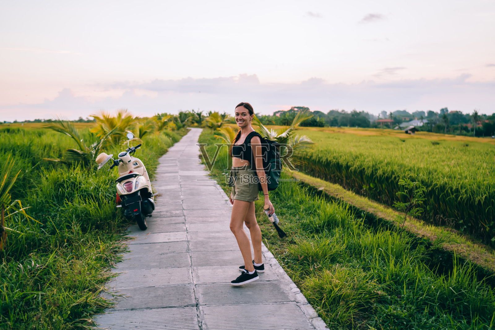 背着背包的快乐女人站在路上照片摄影图片