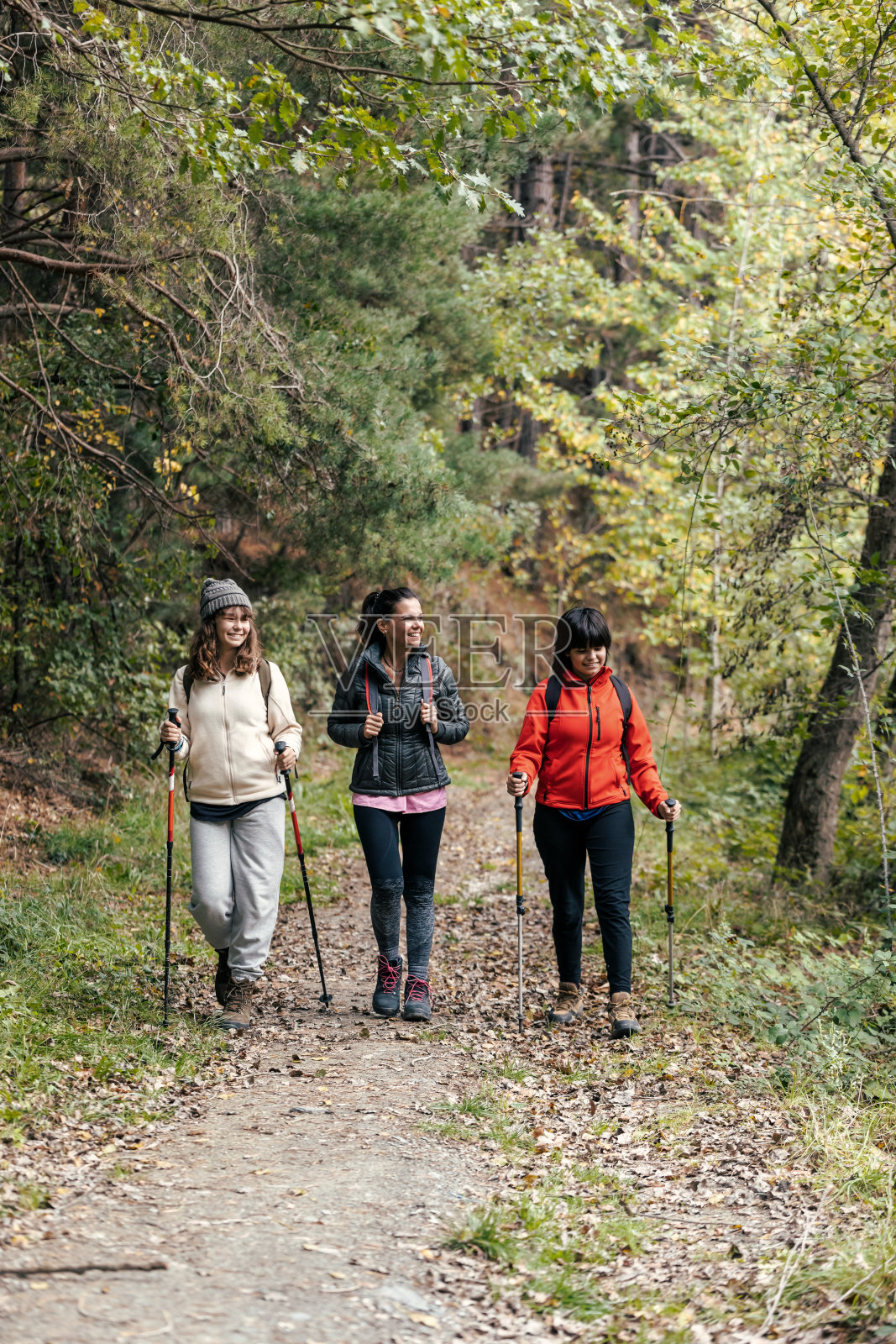 美丽的家庭徒步旅行者背着背包散步，一边看山中的风景照片摄影图片