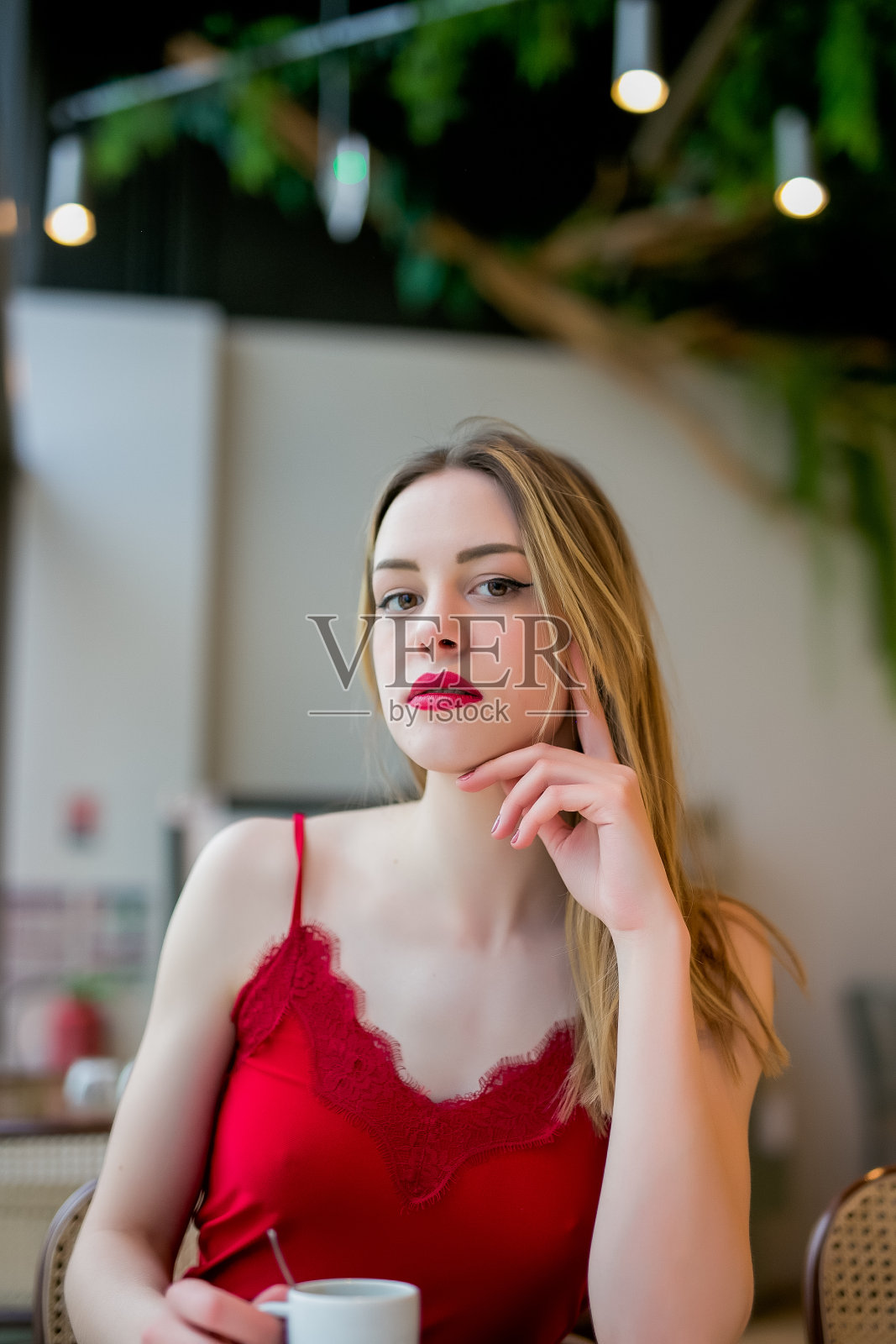 严肃的金发女子在餐厅喝咖啡看着相机照片摄影图片