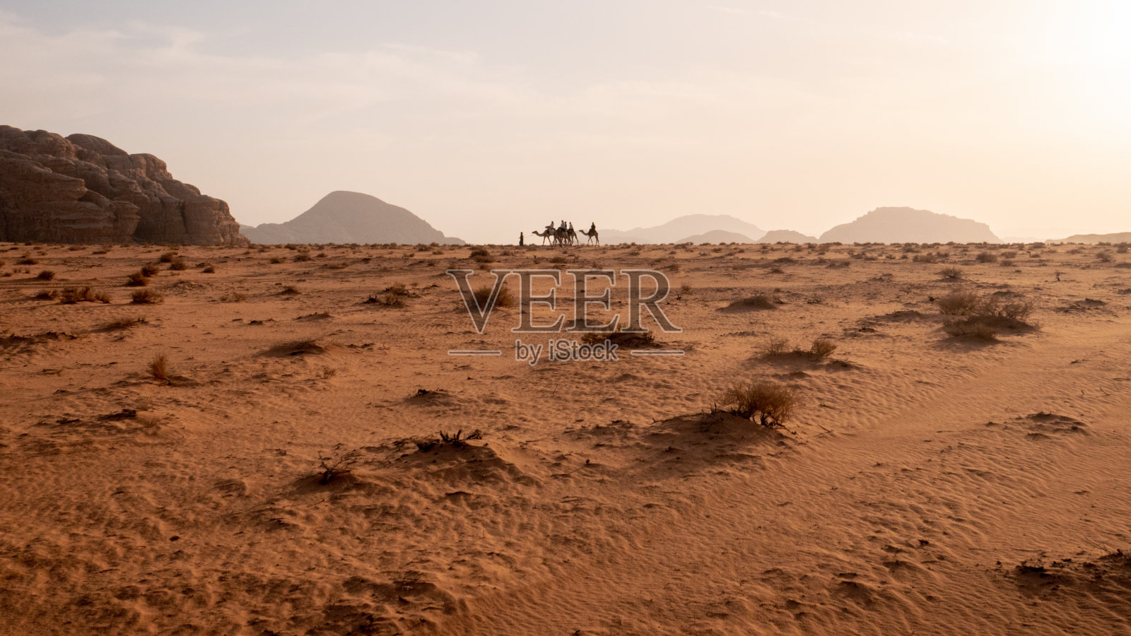 一队骆驼正走过瓦迪拉姆沙漠。照片摄影图片