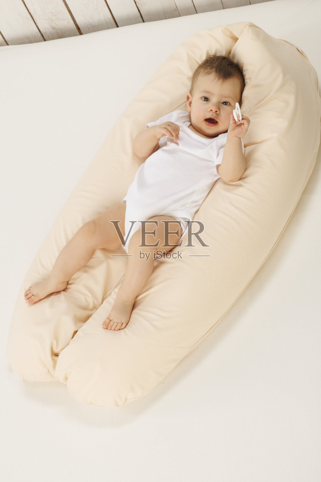 快乐的宝宝，带着奶嘴，玩耍，躺在背上。照片摄影图片