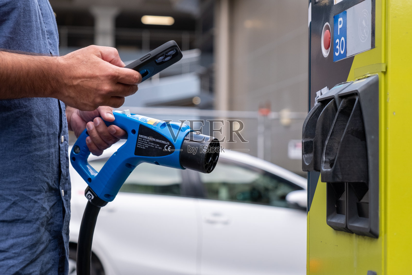 电动汽车充电与手机联网照片摄影图片