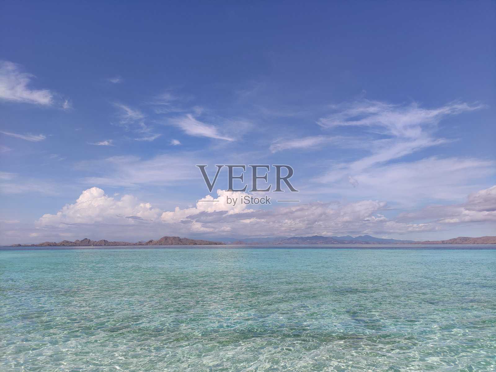 阳光灿烂的日子里，海滩、云彩和大海照片摄影图片