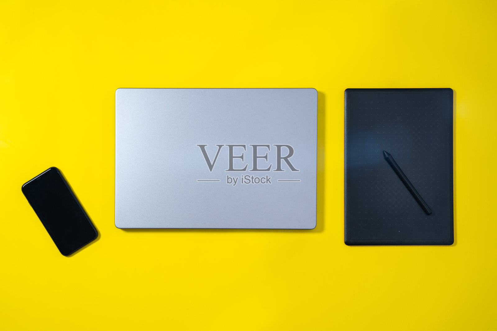 商务工作空间平铺。现代笔记本电脑，手机与空白的白色屏幕和电脑鼠标在黄色背景。高角视图。照片摄影图片