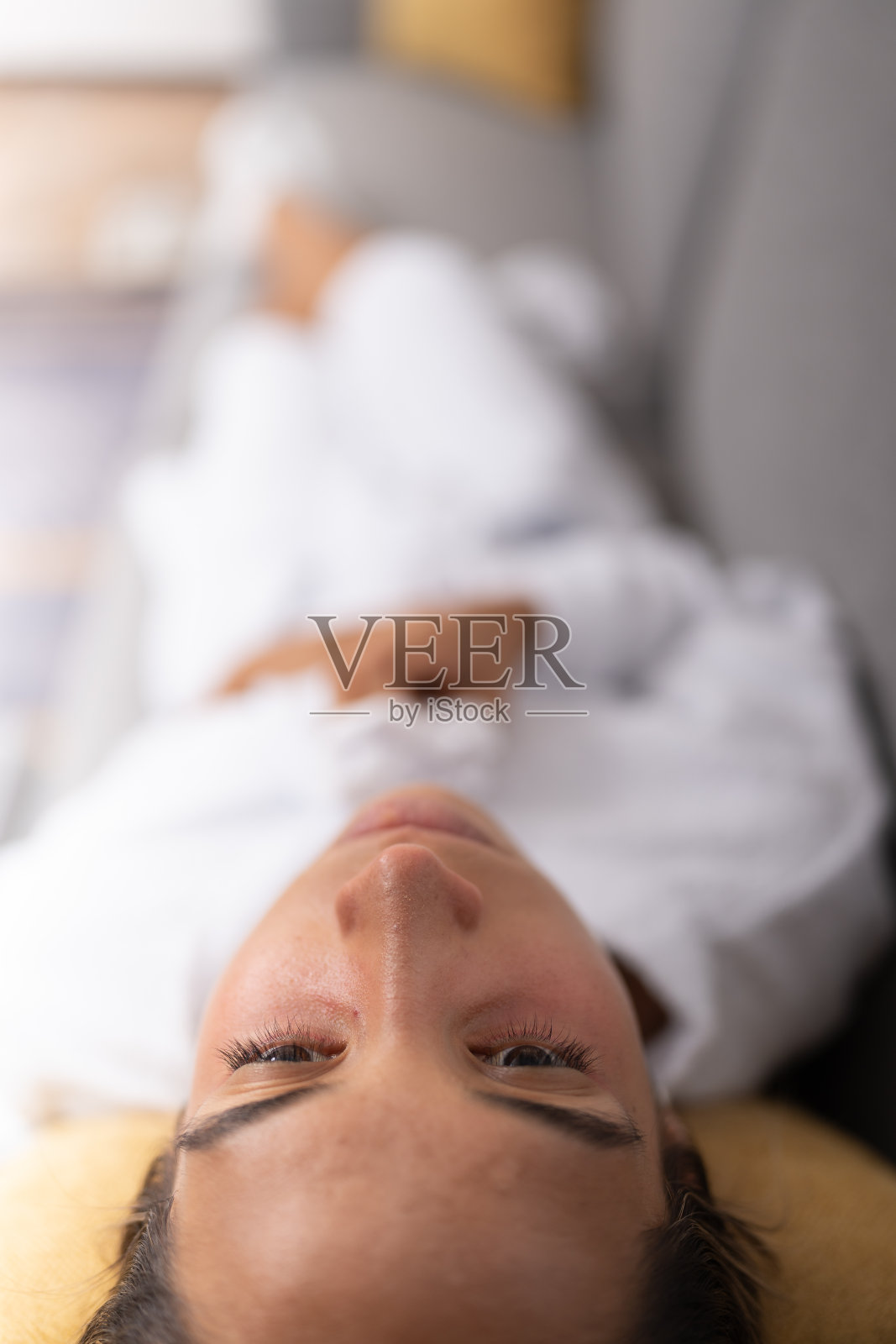 患有严重偏头痛的年轻女性，躺在沙发上照片摄影图片