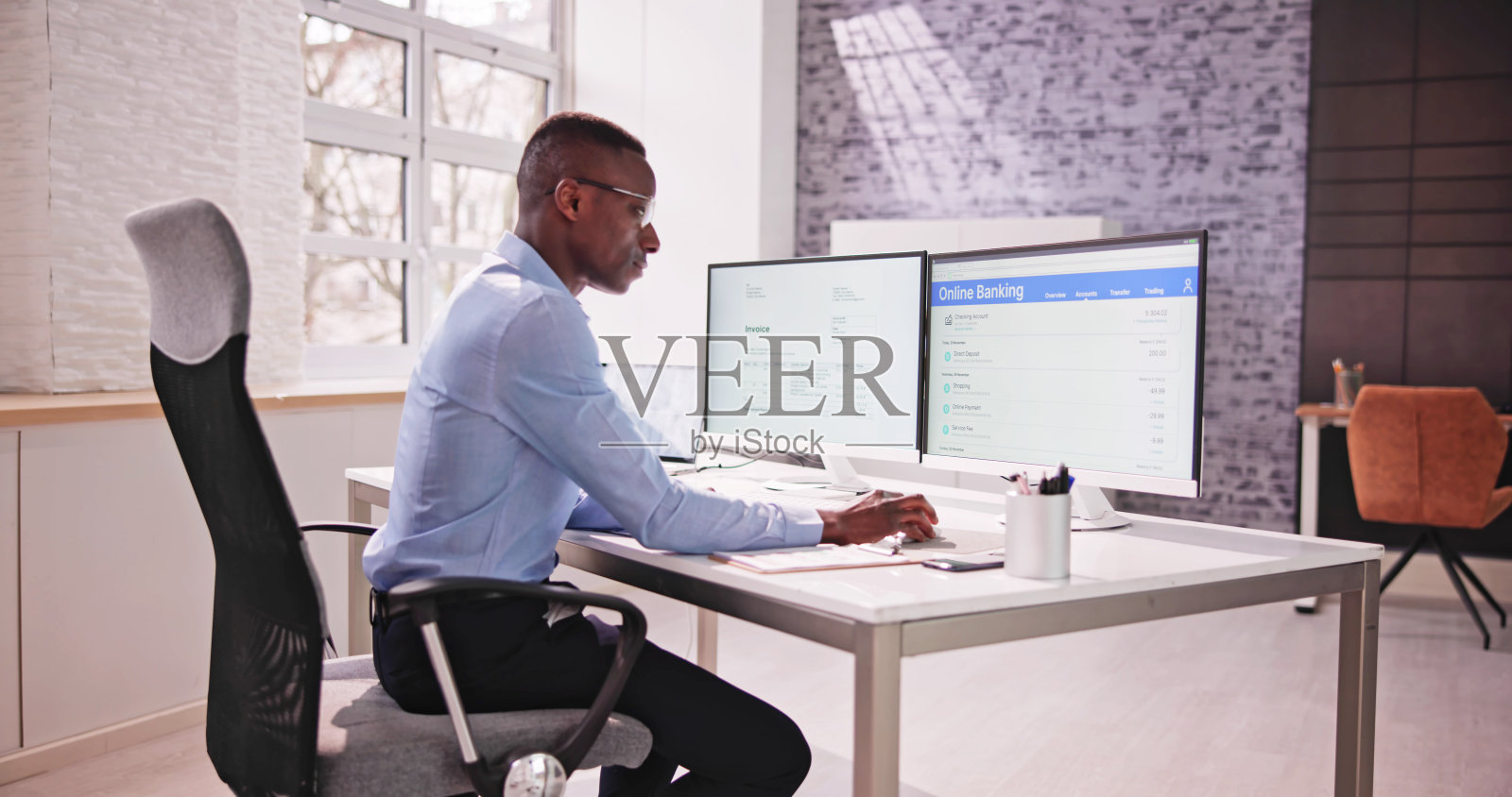 年轻的商人看着发票，而做网上银行照片摄影图片